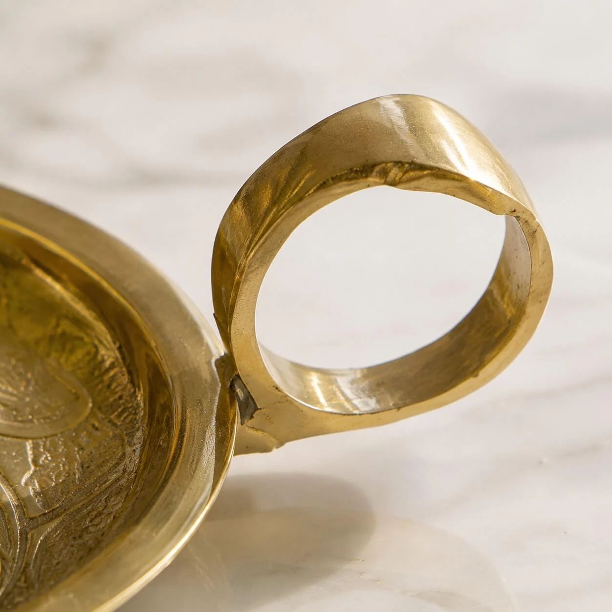 Ring handle detail on brass candle holder