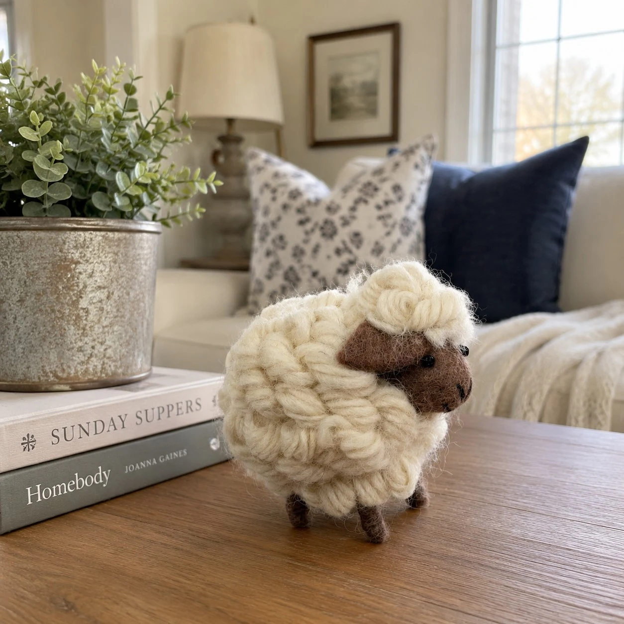 handmade sheep figurine styled with books and greenery