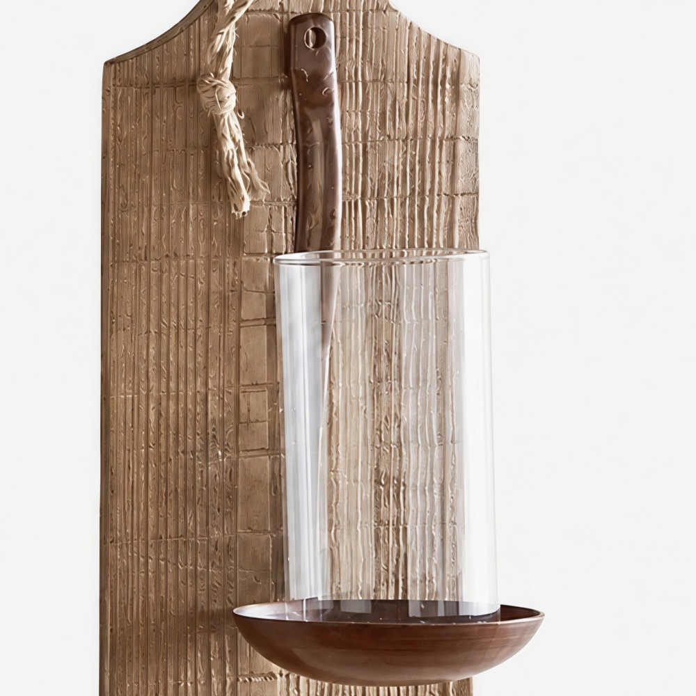 Close detail of iron candle cup and wall-mounted holder