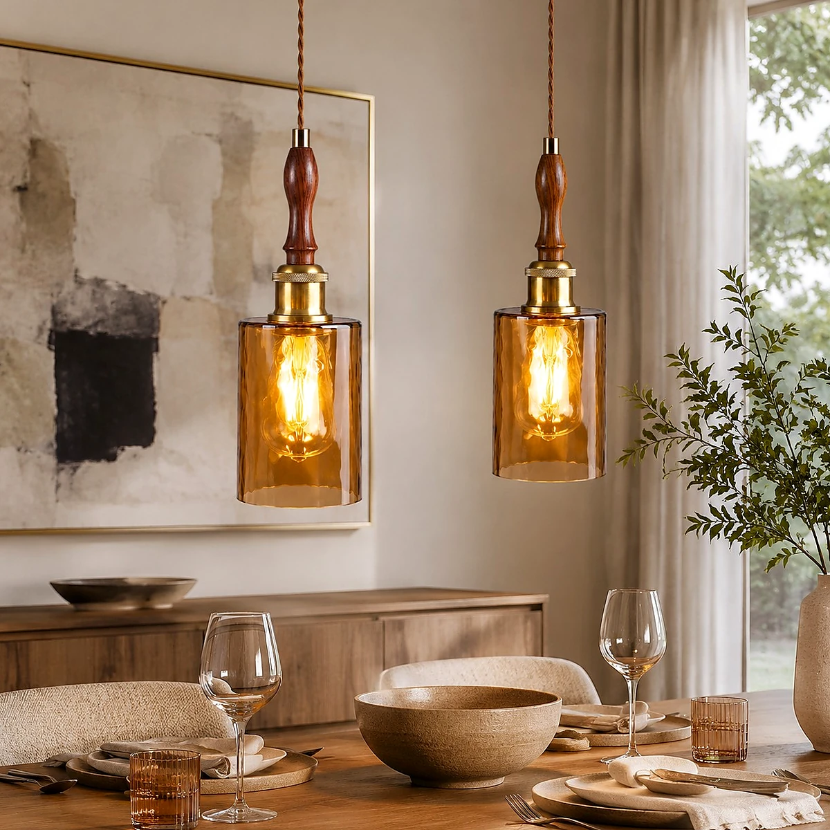 Pair of amber glass wood pendant lights above a dining table