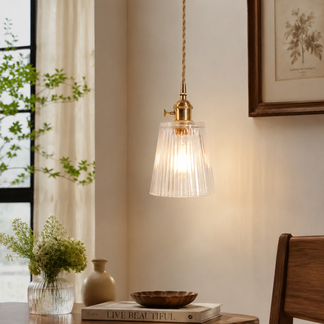 Style L clear glass pendant suspended near a bright window