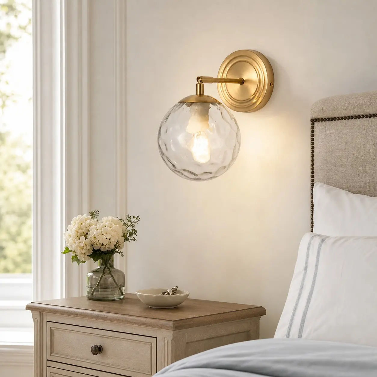 Rippled glass wall lamp above a wood bedside table