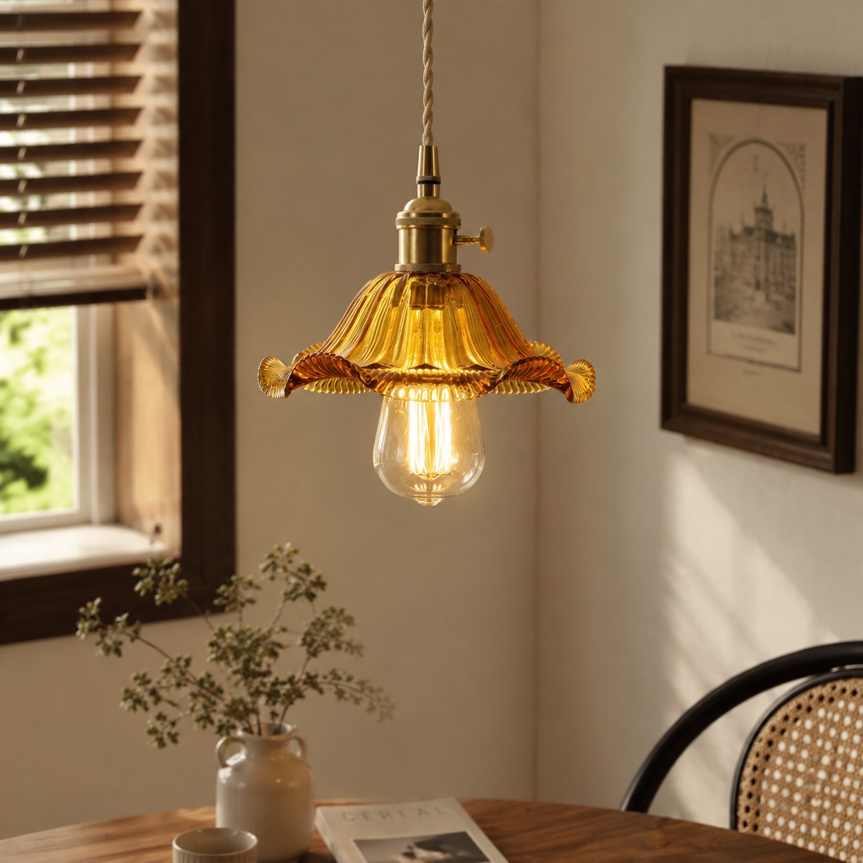 Style L amber glass pendant glowing beside a rattan chair