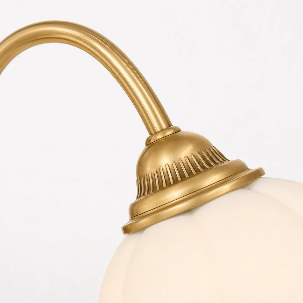 Close-up of brass arm and glass shade connection