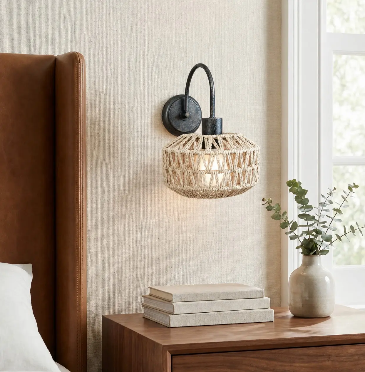Woven rattan wall sconce beside a warm bedroom setting