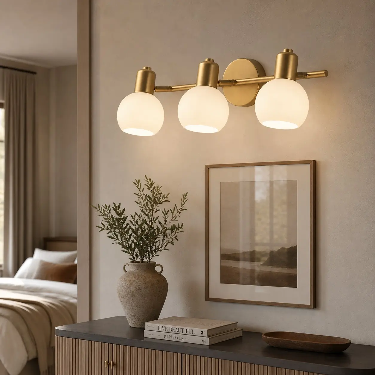 Three-light gold wall sconce in a refined hallway