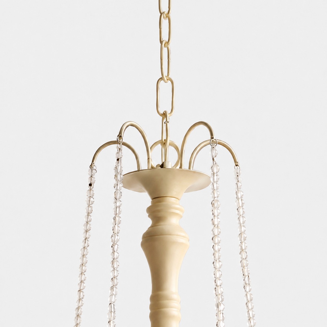 Close-up of gold-tone hanging chain and crystal bead suspension details